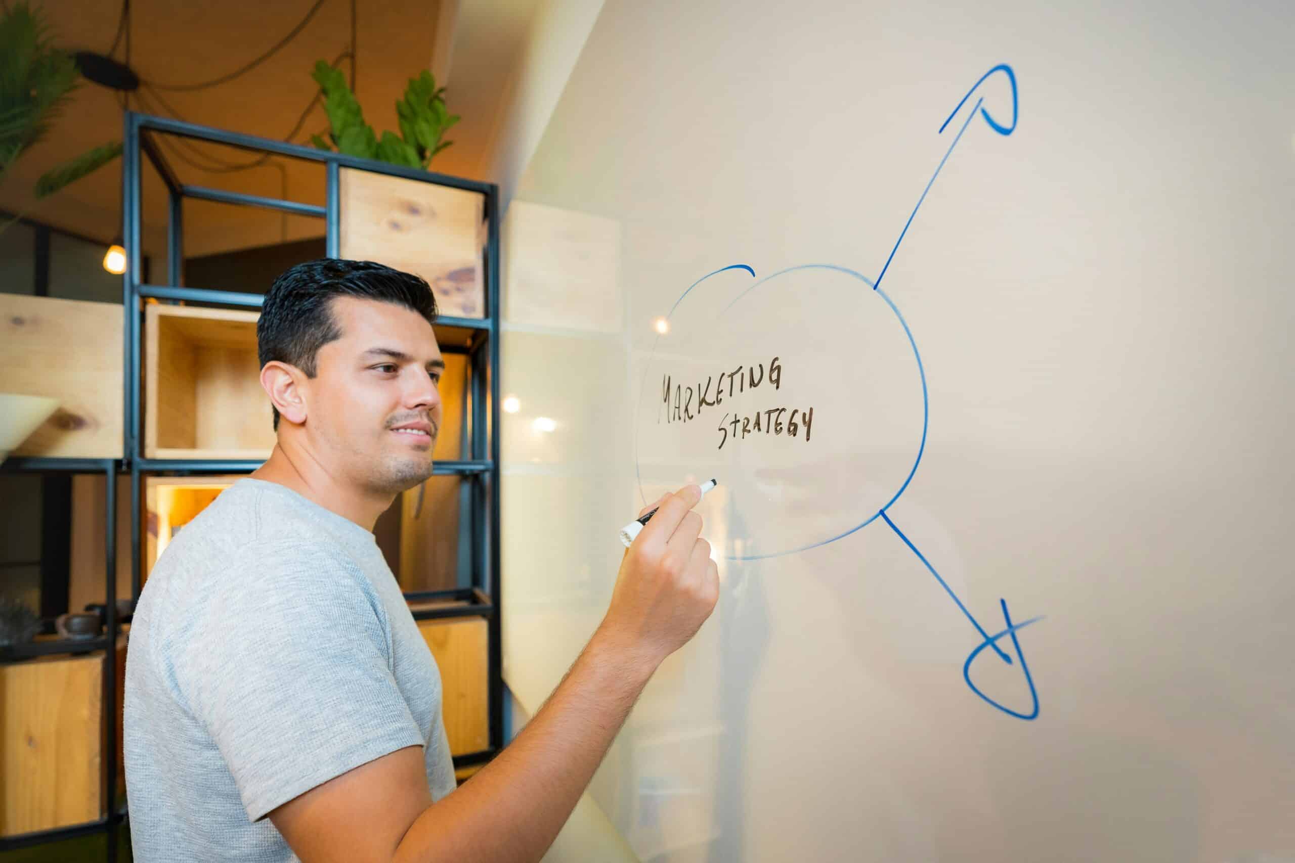 a marketer writing "marketing strategy" on white board